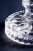ست آجیل‌خوری و پیاله کریستالین الیسا با بدنه شیار‌دار، پایه تراش‌خورده و پر شده از آجیل مخلوط روی پس‌زمینه تیره