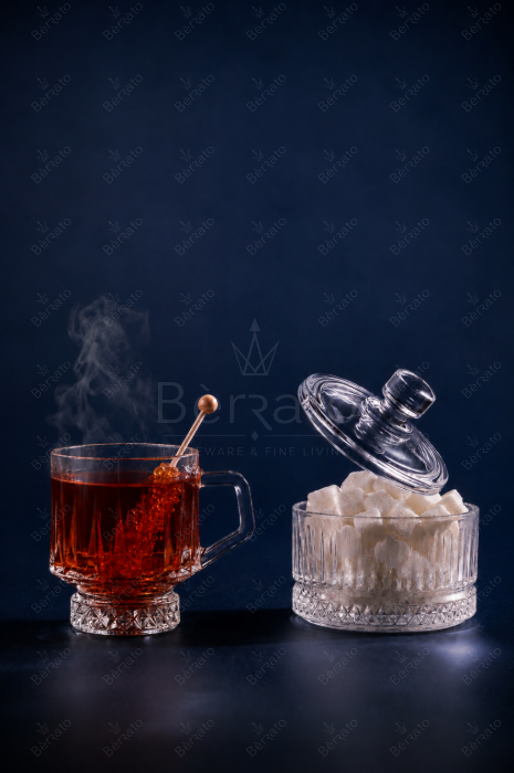 ست فنجان و قندان کریستالین الیسا با بدنه شیاردار، پایه تراش‌دار، فنجان چای بخاردار و قندان درب‌دار حاوی قند
